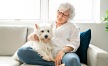 a woman sitting on a couch with a dog